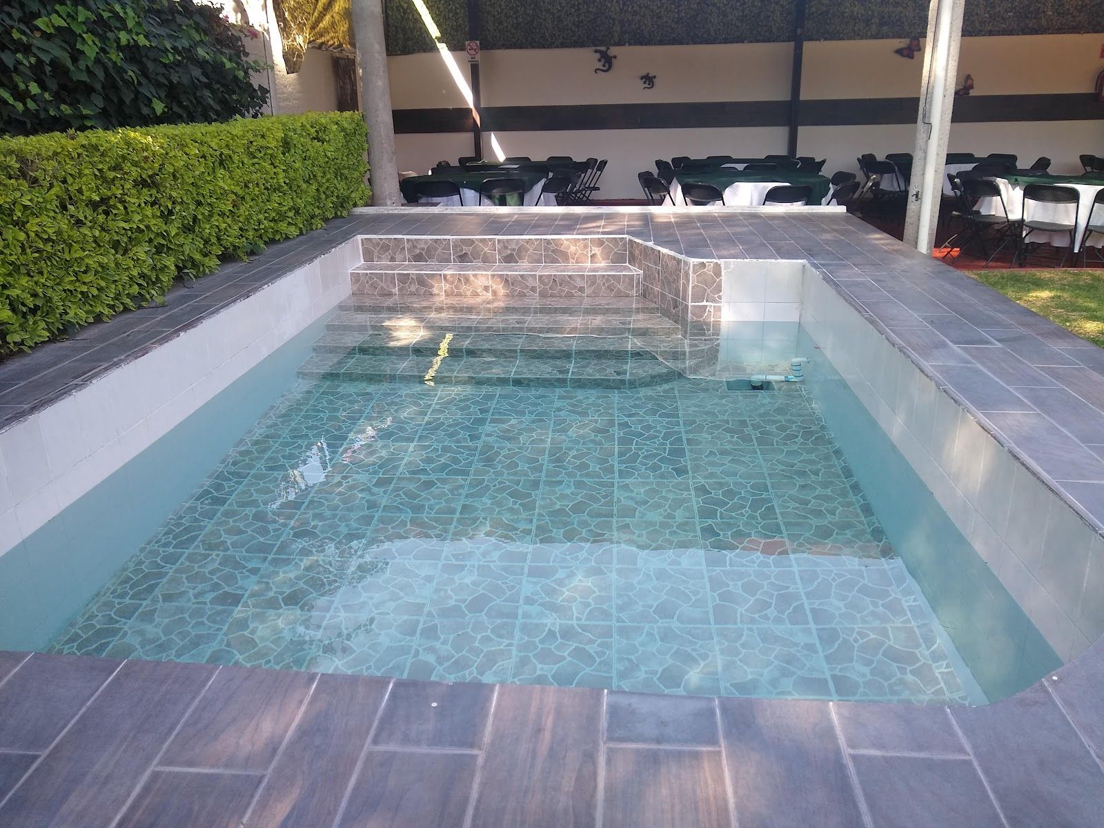 Alberca rectangular con deck de piedra alrededor
